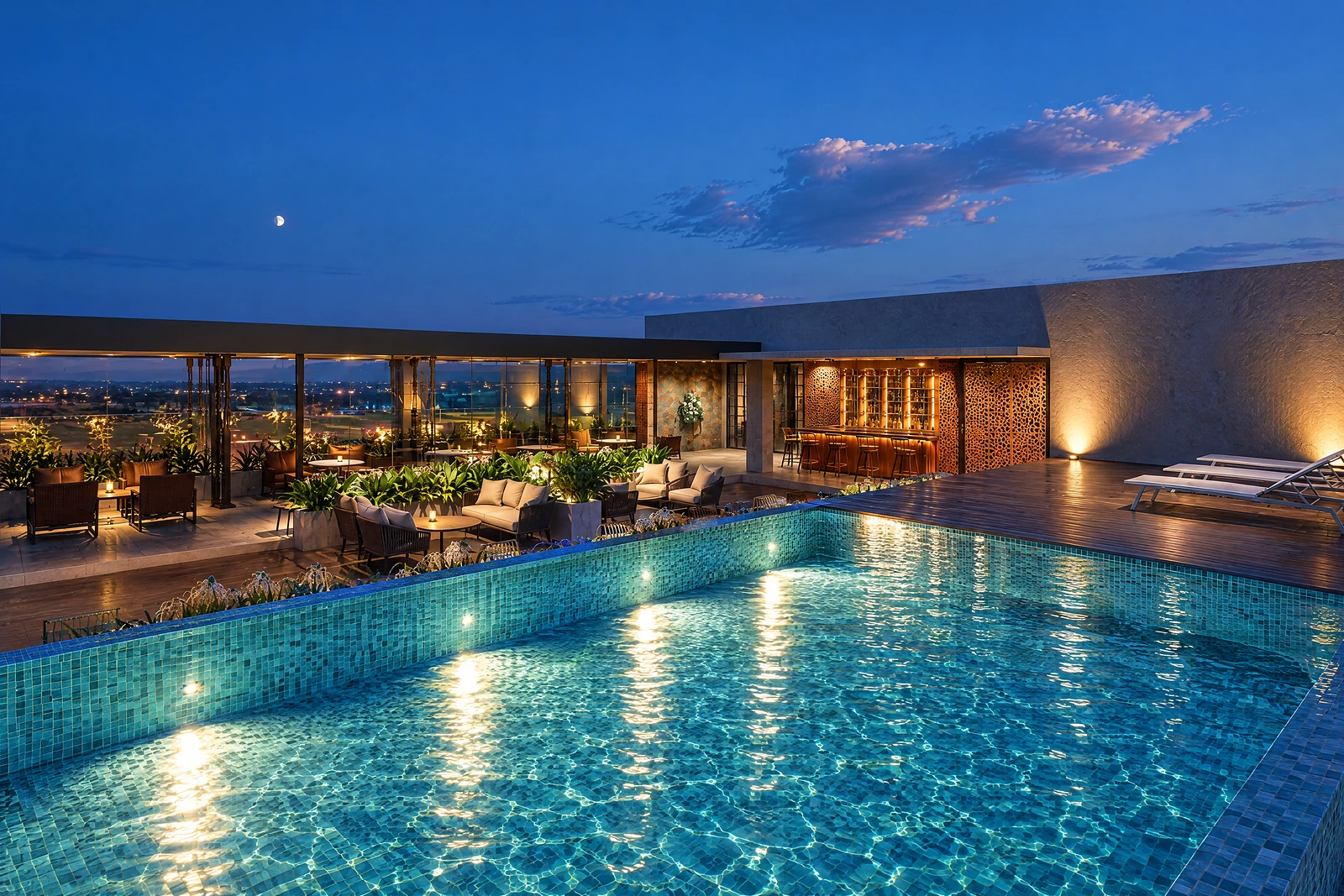 Crown at blue hour: infinity pool, timber deck and bar under a half moon