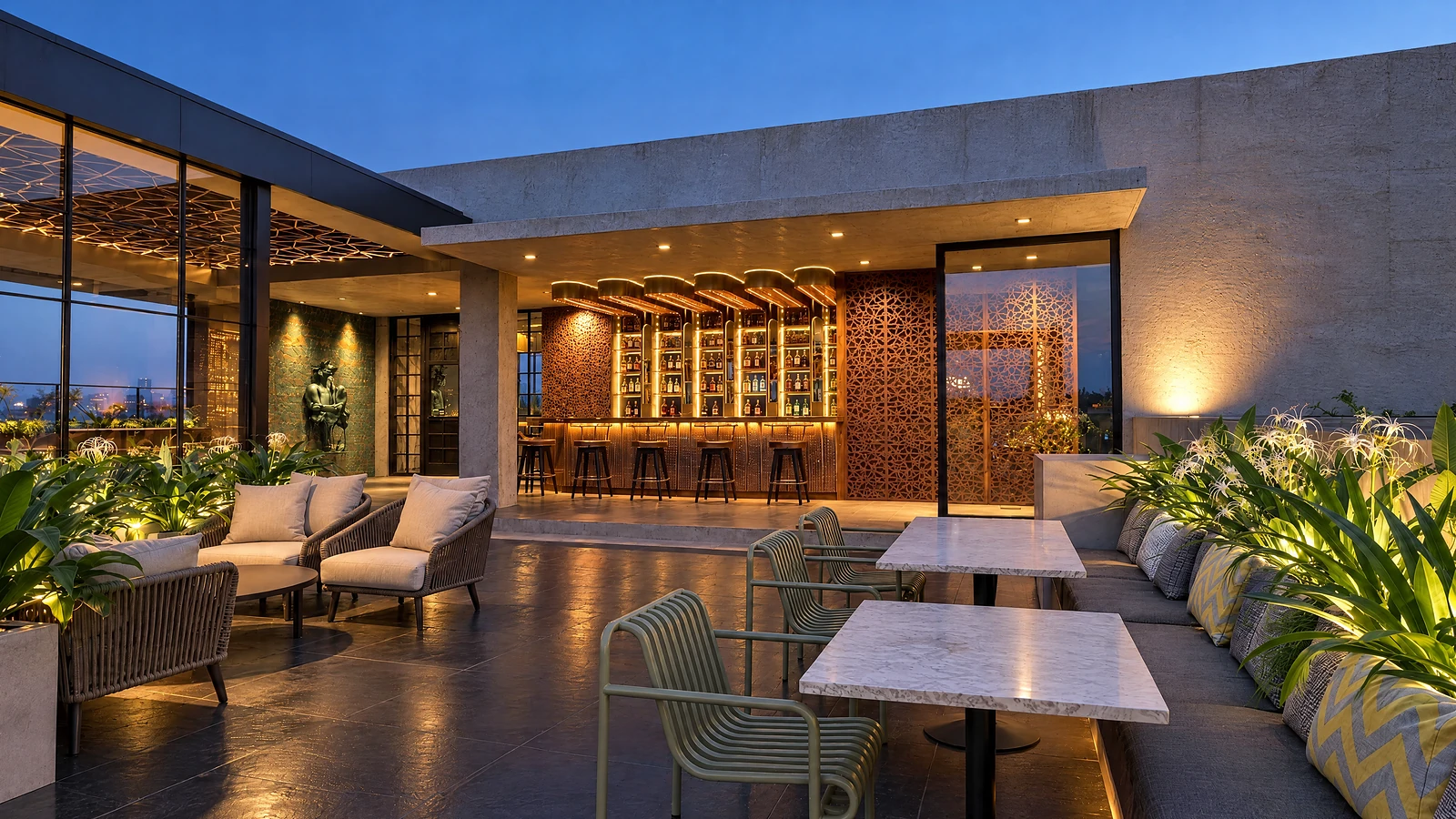 The open terrace and bar at Crown at dusk, planted beds and pale stone tables